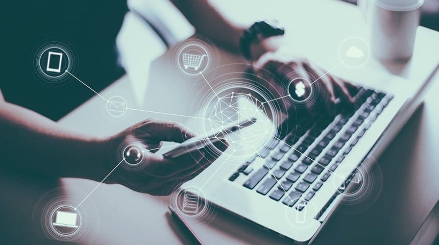 Foto de um homem apoiado em uma mesa com um notebook, segurando uma caneta com ícones de Internet saindo dela, representando a facilidade de trabalhar de qualquer lugar